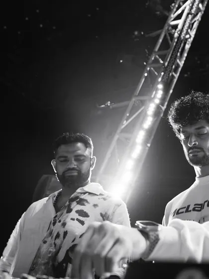 A black and white shot of me and Kayvee during a B2B set for a NOBO experience. The focus is purely on the music and our interaction.