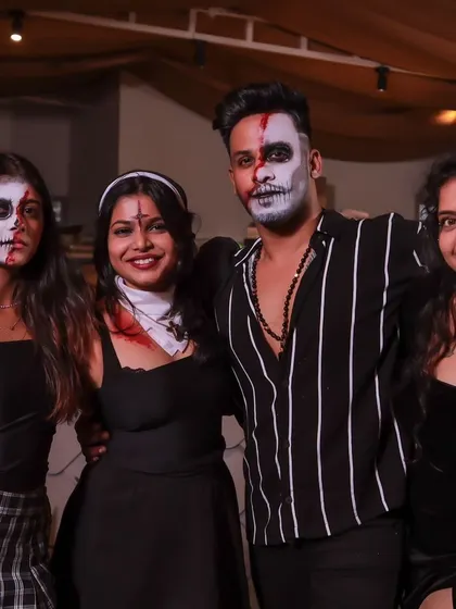 A group of friends showing off their coordinated spooky makeup and outfits.