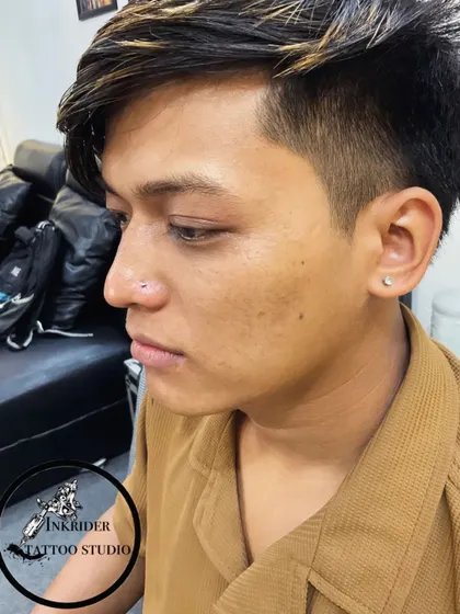 A profile view of a male client with a fresh nose piercing. I offer piercing services for everyone, ensuring a professional experience.