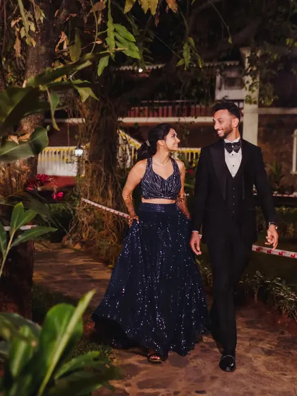 The couple takes a stroll through the beautifully lit venue during their Sangeet night, a quiet moment together amidst the celebration.