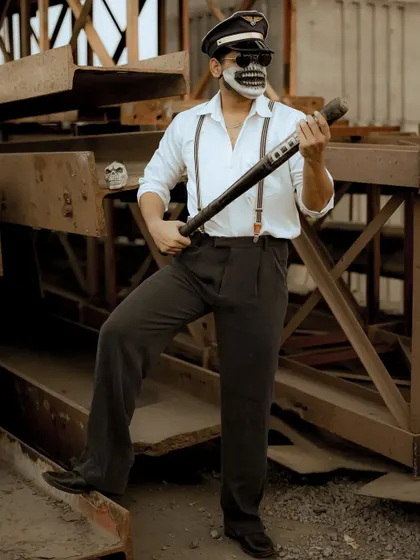 A full-body shot that showcases the entire stylized outfit, including the suspenders and pilot hat.
