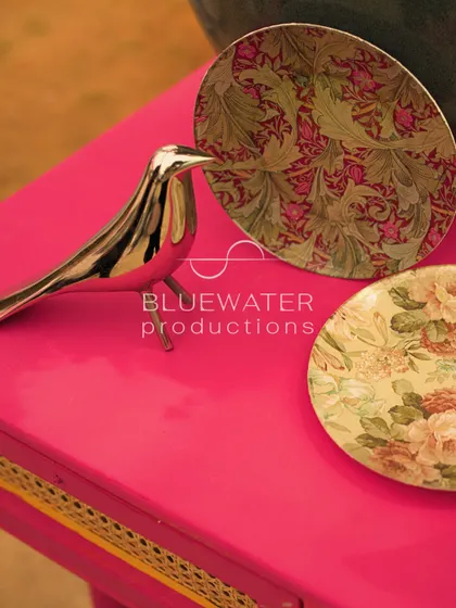 A silver bird figurine and floral-patterned plates add to the quirky and artistic details of the table decor.