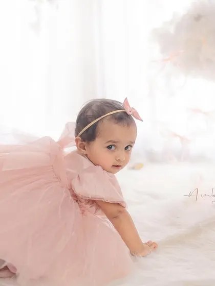 A baby girl on the move during her first birthday cake smash session. I love capturing these active, playful moments that show off your child's personality.