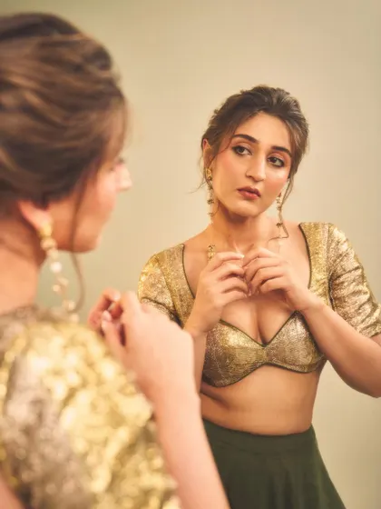 A candid moment of getting ready. This image captures the final touches, adjusting the jewelry to complete the festive look.