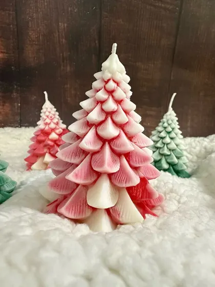 A beautiful red and white ombre Christmas tree candle, adding a cute and festive touch to your home.