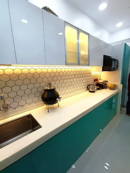 A detailed shot of the countertop, showcasing the hexagonal backsplash, the undermount sink, and the frosted glass cabinet shutters that add a touch of elegance.