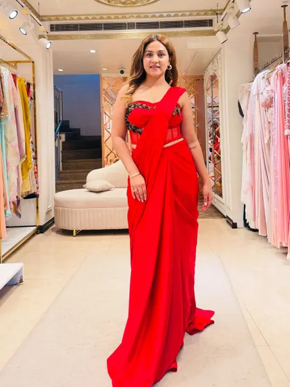 This stunning red corset saree is a perfect example of modern Indian wear. The corset blouse cinches the waist and adds glamour, while the pre-draped crepe fabric is fuss-free and creates a beautiful, elongated silhouette.