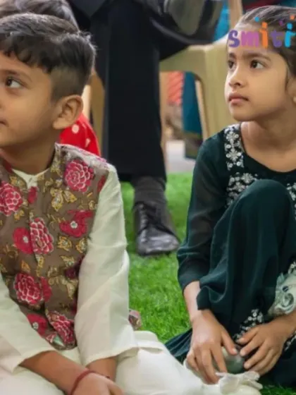 Two children watch the Grandparents' Day performances with rapt attention. These shared experiences create lasting memories for our students.