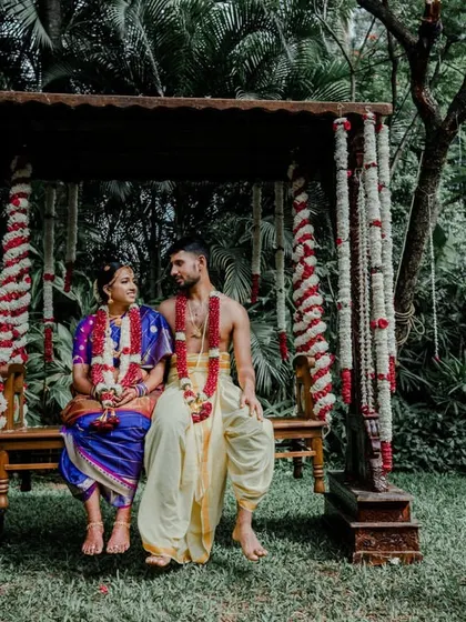 A quiet moment between the couple on a rustic wooden swing adorned with flower garlands, set in a peaceful garden.