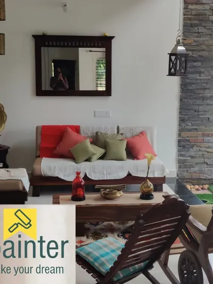 A cozy living room with off-white walls that create a bright and airy feel. The neutral color provides a perfect backdrop for the rustic wooden furniture and stone accent wall.