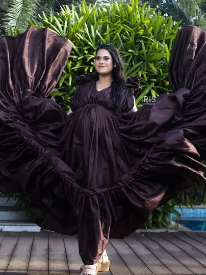 This flowing brown taffeta gown creates a stunning silhouette, especially when tossed for a dramatic effect. It's a versatile piece that works beautifully for both poolside and beach maternity shoots.