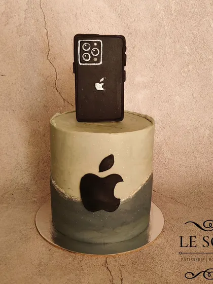 An iPhone 15 Pro Max cake for the Apple enthusiast. This 1 kg chocolate cake features a sleek grey and black design with the Apple logo and a fondant phone on top.