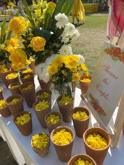 A simple yet beautiful detail for a haldi ceremony: terracotta kullads filled with fresh yellow flower petals for guests to shower the couple.
