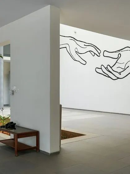 A wall mural in the lobby depicts two hands reaching for each other, symbolizing the hospice's mission of compassionate care.