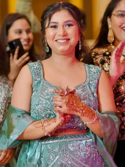 A happy guest in a sea-green mermaid gown, her smile is absolutely radiant.