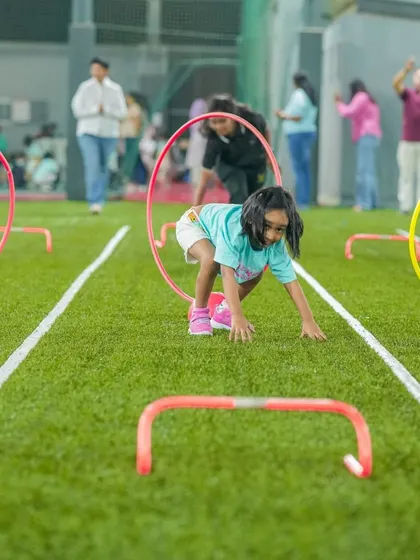An obstacle course in action. A child crawls through a hoop, demonstrating agility and a can-do attitude.