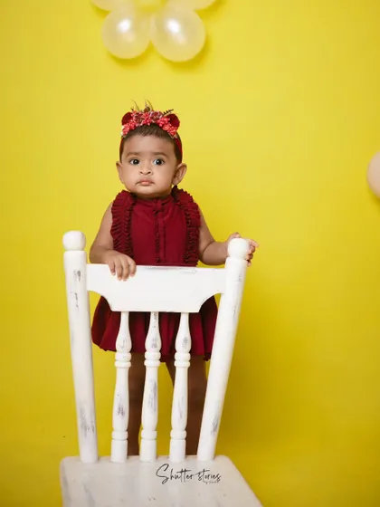 A simple and bold setup with a red outfit against a bright yellow background, perfect for a minimalist cake smash.