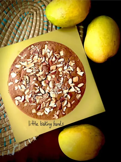 The vegan mango nuts cake, pictured with fresh mangoes. It's a beautiful, seasonal, and completely plant-based treat.