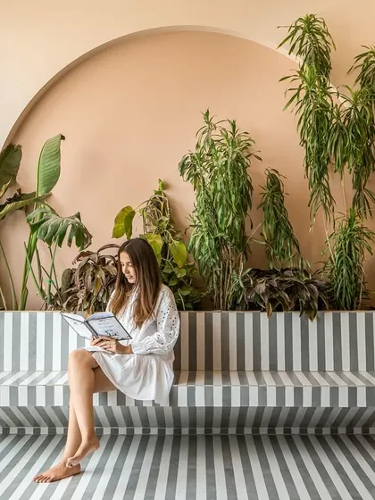 The semi-open terrace features a striking striped floor made from water-jet cut tiles, which extends into a built-in bench. It's a perfect spot for quiet moments surrounded by greenery.