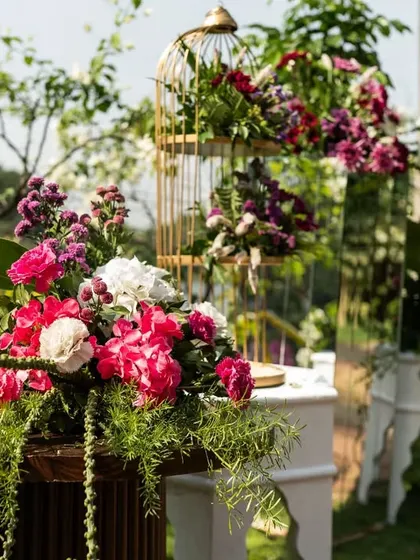 A beautiful floral arrangement in a birdcage, a popular element in vintage and rustic wedding decor.