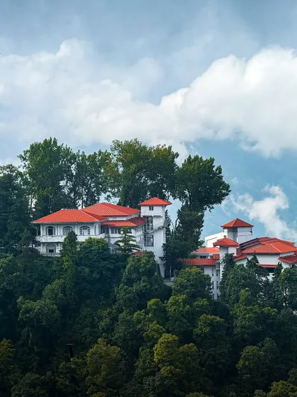 A beautiful villa with a red roof nestled among the trees in Mussoorie. The colors are so vibrant, captured perfectly on my phone.