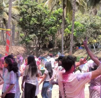 Guests with hands in the air, fully engaged with the DJ and the high-energy music at the corporate Holi party.