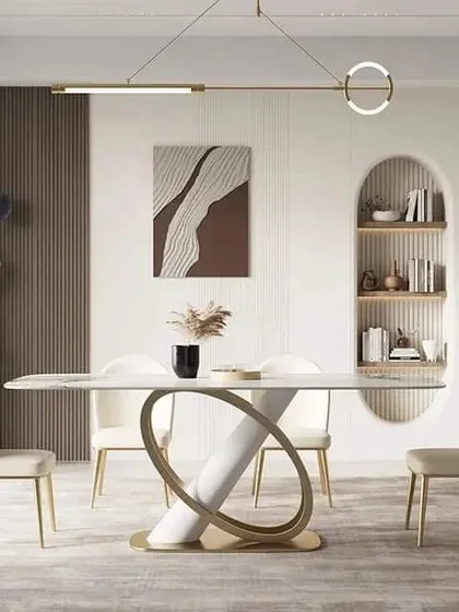 A modern and artistic dining set featuring a white tabletop with a unique sculptural base, paired with minimalist chairs and contemporary lighting.