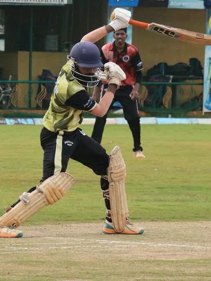 A batter swings hard at the ball during a T20 style youth match.