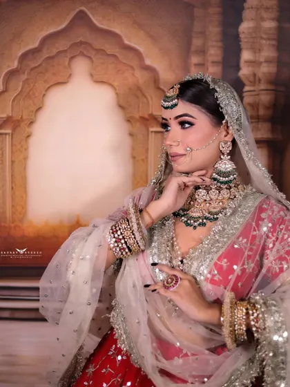 A side profile of the bride, looking away thoughtfully. This pose highlights her elaborate earrings and the side details of her hair and makeup.