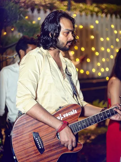 Live music adds so much to an event's atmosphere. This photo captures a guitarist mid-performance at a party, with the warm background lights creating a perfect stage-like setting.