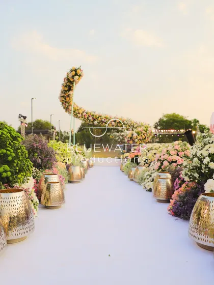 A unique curved floral arch marks the entrance to the wedding aisle, creating a stunning photo opportunity.