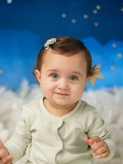 A close-up of this little star, her bright eyes and sweet expression stealing the show. Sitter sessions are ideal when your baby can sit up but isn't crawling yet.