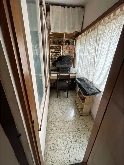 **BEFORE:** A narrow, unused balcony space with old curtains, serving little purpose.