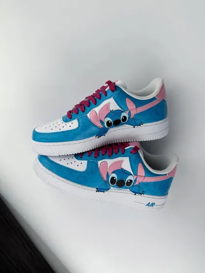 Another view of the Stitch custom sneakers, showing him playfully interacting with the Nike swoosh.