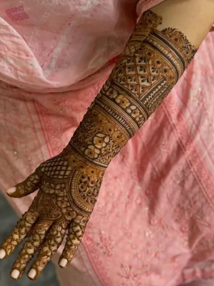 The back of the hand featuring multiple bands of intricate geometric patterns, creating a beautiful sleeve effect.