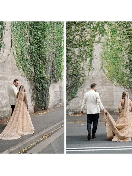 A walk to remember. The bride's stunning golden lehenga with a long trail and the groom's classic white tuxedo create a timeless and elegant look for their wedding day.