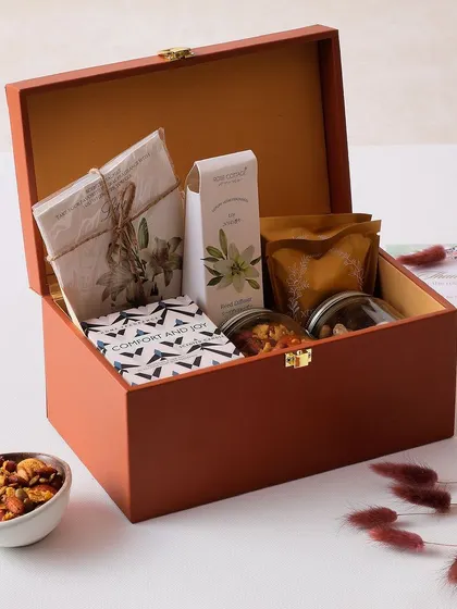 This hamper is perfect for creating a cozy festive atmosphere. It includes a candle, room diffuser, fragrance sachet, and a selection of brownies, cookies, and trail mix.