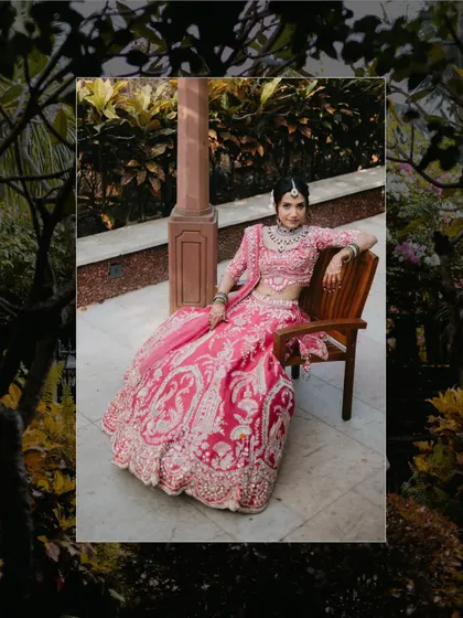 A classic bridal portrait, with the bride seated in a chair, her pink lehenga spread around her, framed by a creative border.
