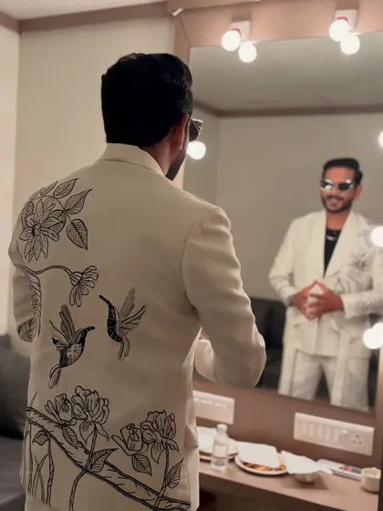 The back of this white suit features stunning black-and-white embroidery of birds and flowers, adding an element of artistry to my look.