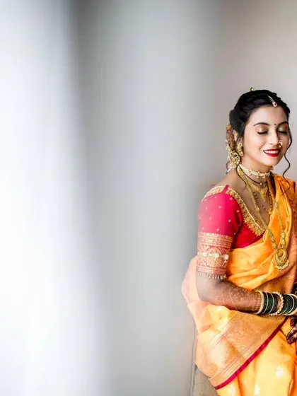 A minimalist bridal portrait with the bride seated, bathed in soft, natural light. The negative space emphasizes her calm and happy expression.