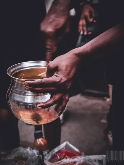 Capturing the process of making bhel puri. The focus is on the hands mixing the ingredients, highlighting the fresh, handmade nature of the snack.