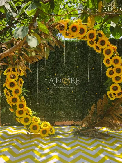 A perfect photo spot for a sunflower-themed event. This circular selfie booth, adorned with bright sunflowers and delicate hanging crystals against a green hedge, was a huge hit with guests.