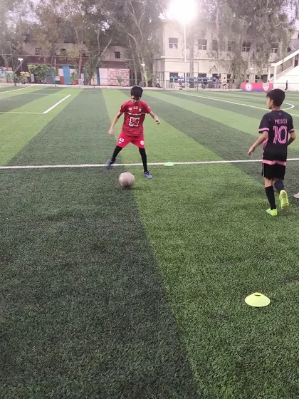 A young player practices his dribbling skills around cones. Foundational drills are the building blocks of advanced football techniques.