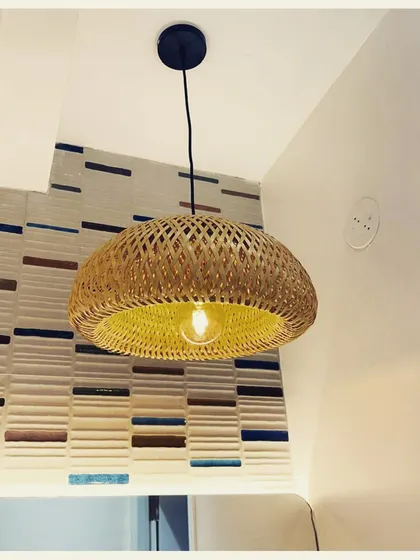 A simple yet beautiful woven pendant light, this fixture adds a touch of boho elegance to this corner. Its warm glow highlights the textured wallpaper behind it, creating a cozy and inviting atmosphere.