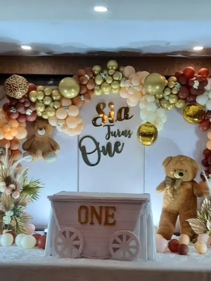 A cute and cuddly teddy bear theme for a first birthday, using a neutral color palette of brown, beige, and gold with adorable bear props.