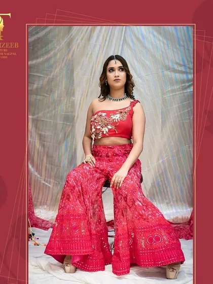A seated pose in the red sharara set, highlighting the comfort and style of the outfit. It's designed to make you look and feel great.