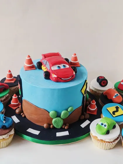 Neil's "Cars" themed birthday cake, featuring a Lightning McQueen figurine and road-themed cupcakes.