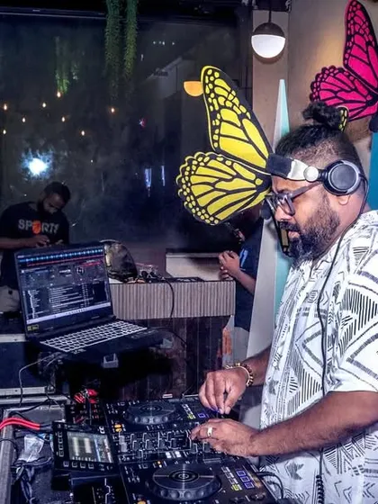 Another shot of me focused on the decks. My setup includes my laptop for VJing, ensuring the visuals are always in sync with the music.