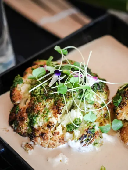 A modern take on a classic vegetable. This roasted cauliflower is served on a creamy base with a vibrant green chutney and delicate microgreens, perfect for a sophisticated wedding menu.
