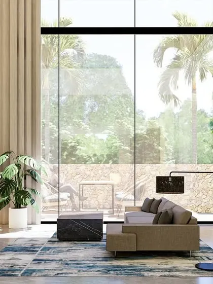 We believe true luxury is about quiet, timeless sophistication, not glitz. This living room embodies that philosophy with its double-height ceilings, natural materials, and floor-to-ceiling windows that flood the space with light and connect it to the outdoors.